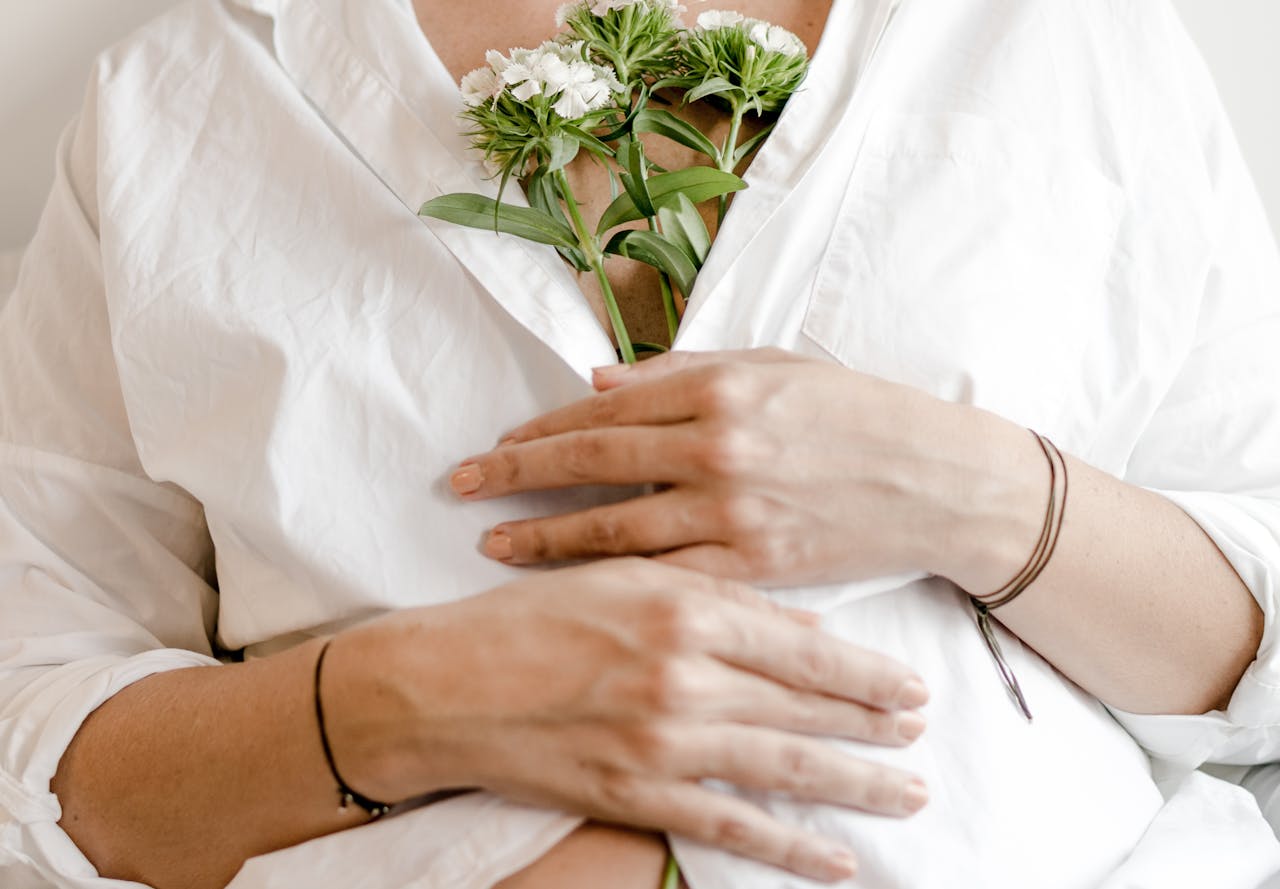 Crop pregnant woman with blooming flower bouquet