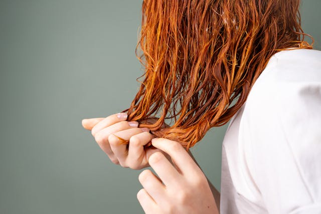 Close-up of Red Hair and Hands in Soft Lighting
