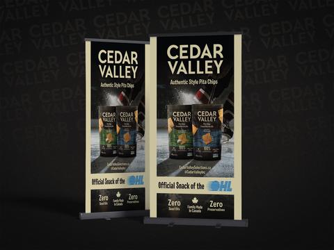 Retractable roll-up banner design for Cedar Valley pita chips brand, two pull-up banners on black background featuring Garlic and Herb and Sea Salt flavors with hockey imagery and Official Snack of the OHL branding