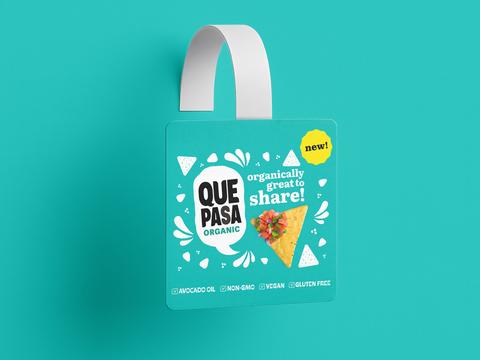Shelf talker wobbler design for Que Pasa organic tortilla chips, teal hanging tag with Organically Great To Share headline, tortilla chip with salsa photography, New badge, and Avocado Oil Non-GMO Vegan Gluten Free callouts
