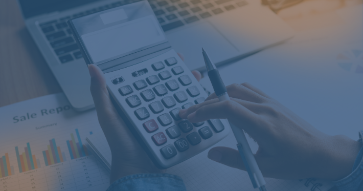 mão usando calculadora em frente ao notebook