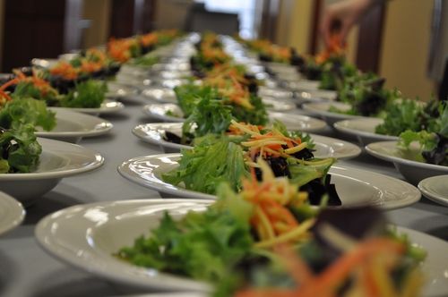 A long table with plates set up for guests.