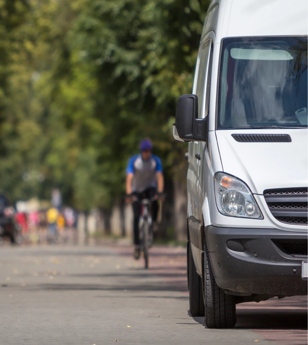 White service van in motion on a tree-lined street