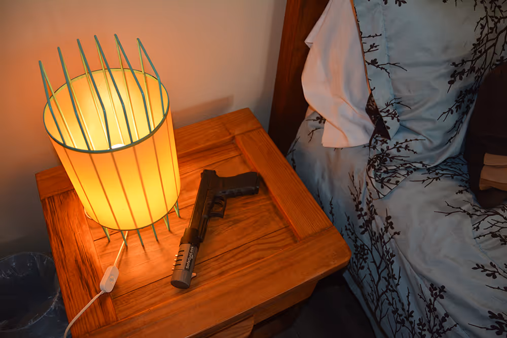 A handgun locked with SafeGunLock placed on a nightstand
