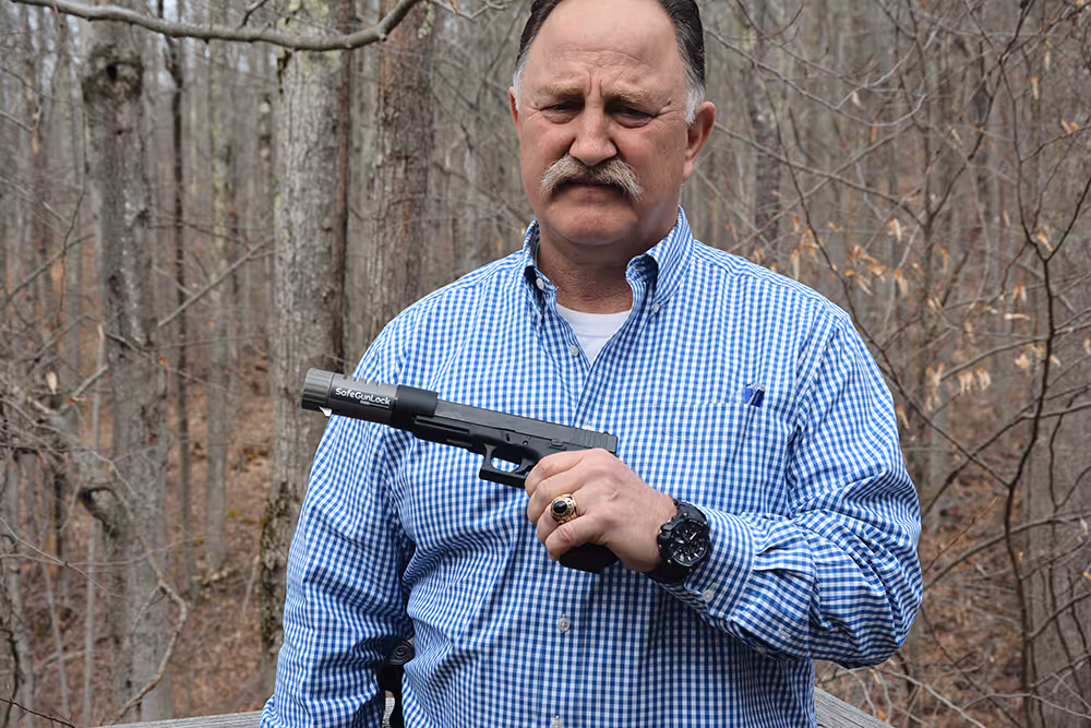 A man holding a handgun with SafeGunLock