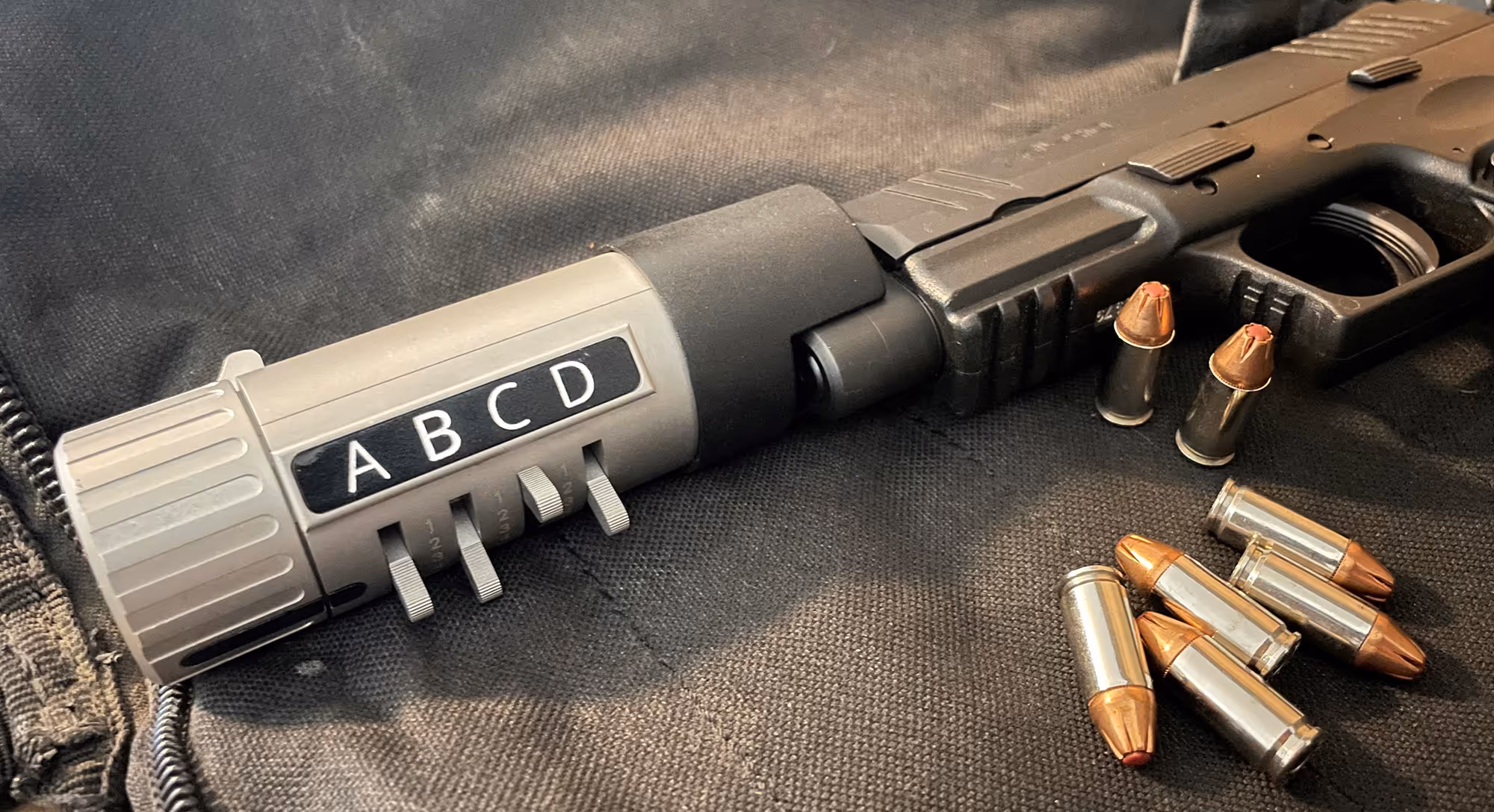 SafeGunLock inserted into handgun next to pile of bullets