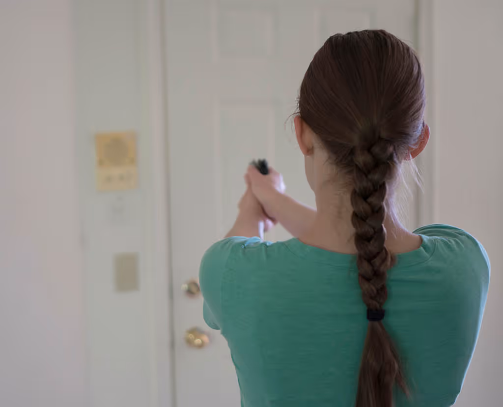 A woman defends her home with a handgun pointed at the front door