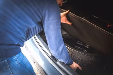 Man checking on his spare tire