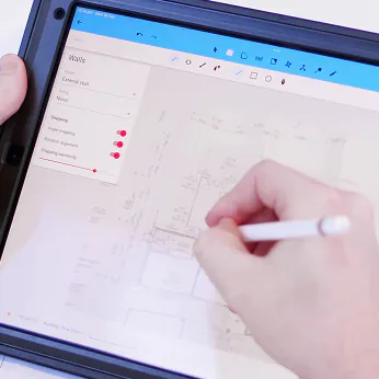 A person writing on a tablet with a pen.