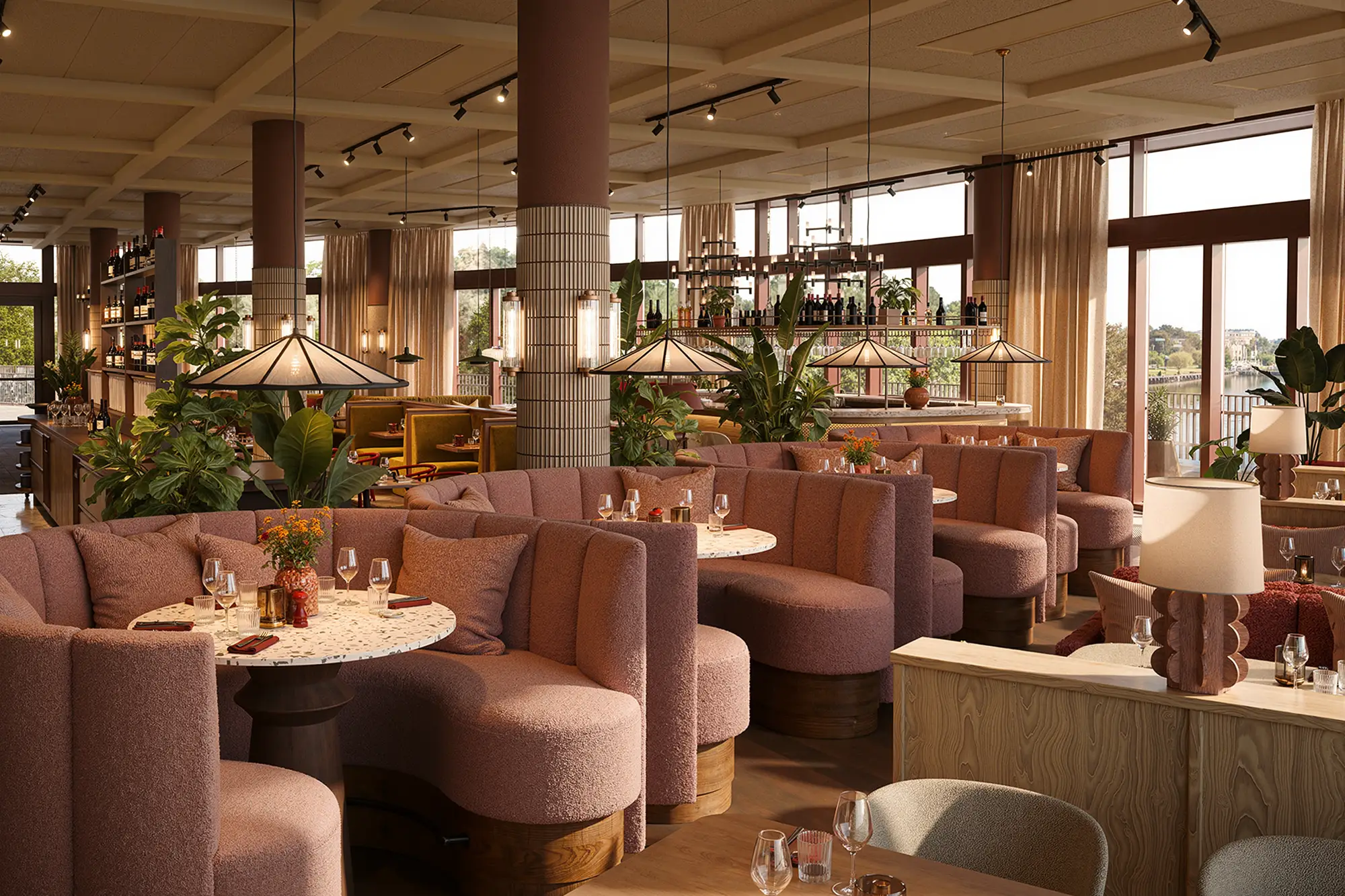 Elegant restauranginteriör med rundade rosa soffor, marmorbord och stora fönster med utsikt över en sjö.