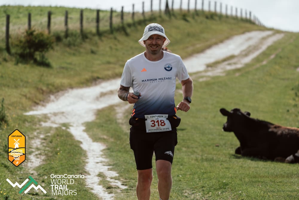 Runner in Maximum Mileage kit on a chalk trail during South Downs Way 100
