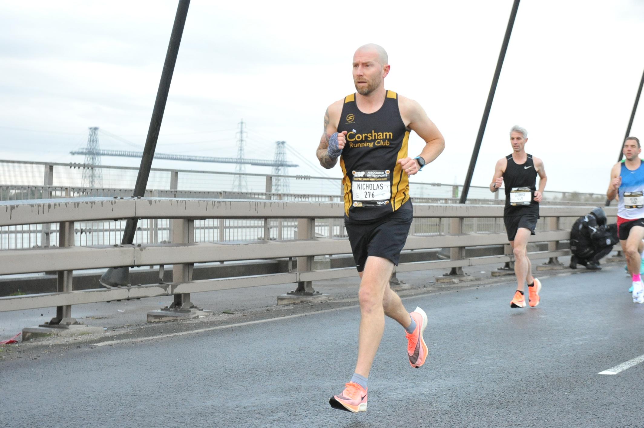 Nick Hancock running across a bridge at Newport Marathon