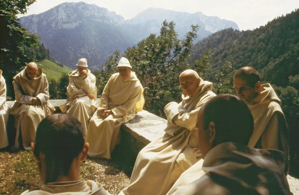 Mönche sitzen auf einer Terrasse in der Sonne