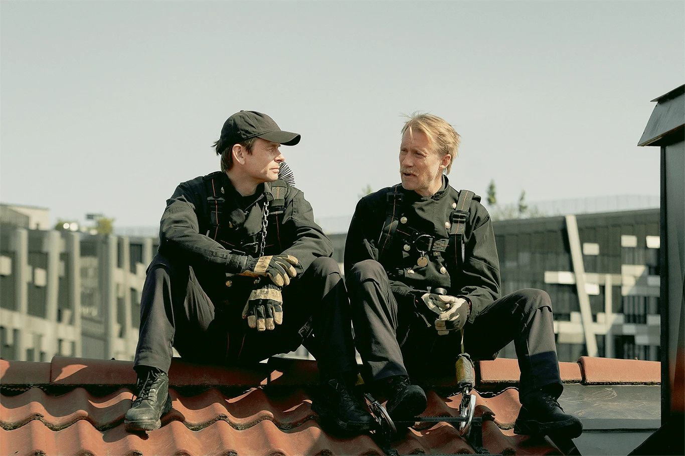zwei Männer sitzen auf einem Dach