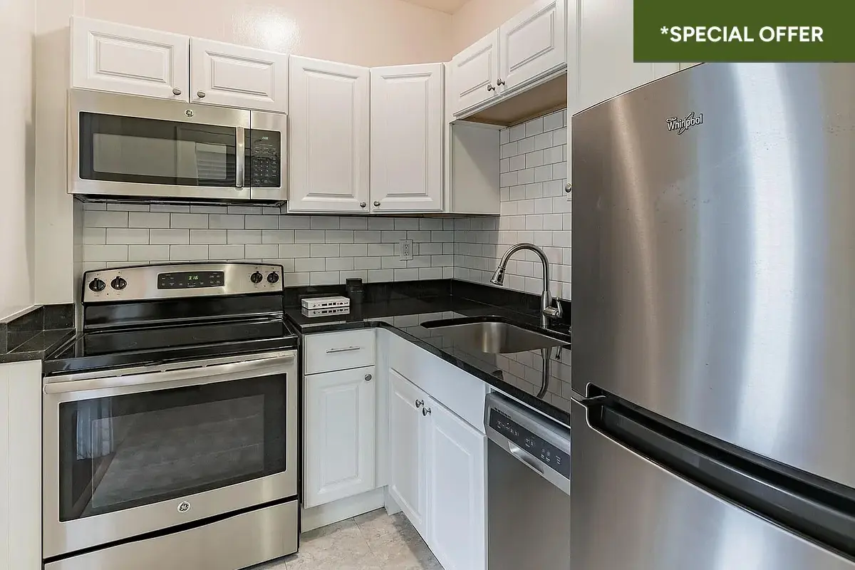 Kitchen with white cabinets and stainless steel appliances with text overlay stating "*special offer."