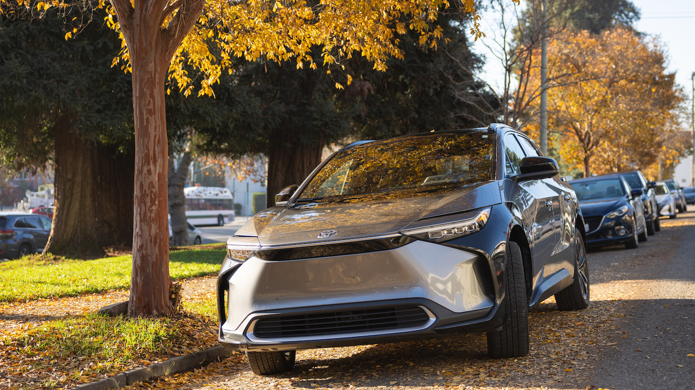An electric vehicle SUV in the driveway of a suburban home.