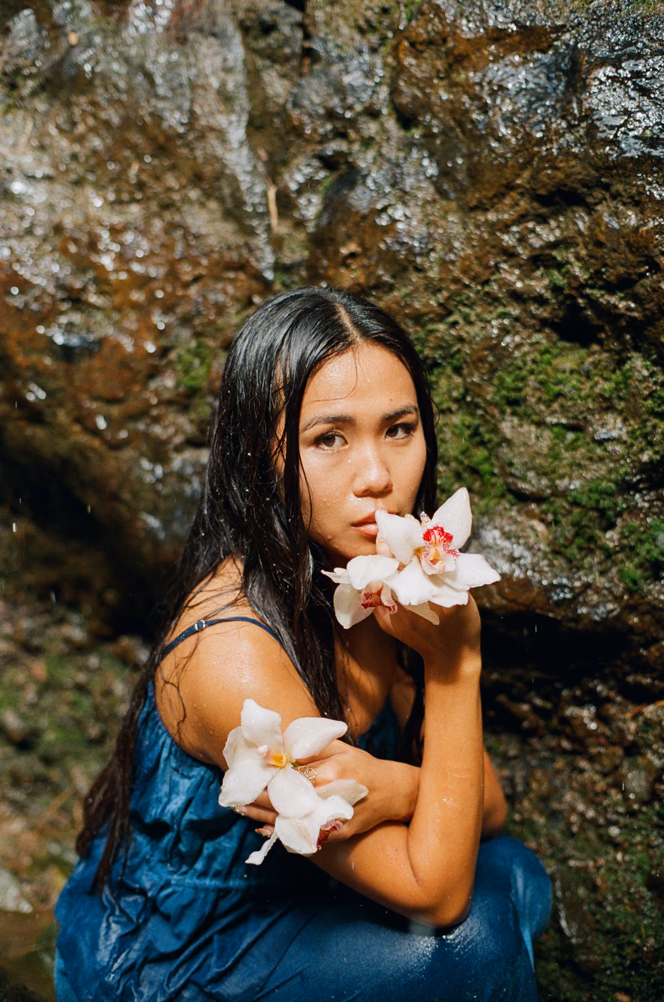 portrait of Cassidy Joys holding orchids on 35mm film in hawaiʻi 