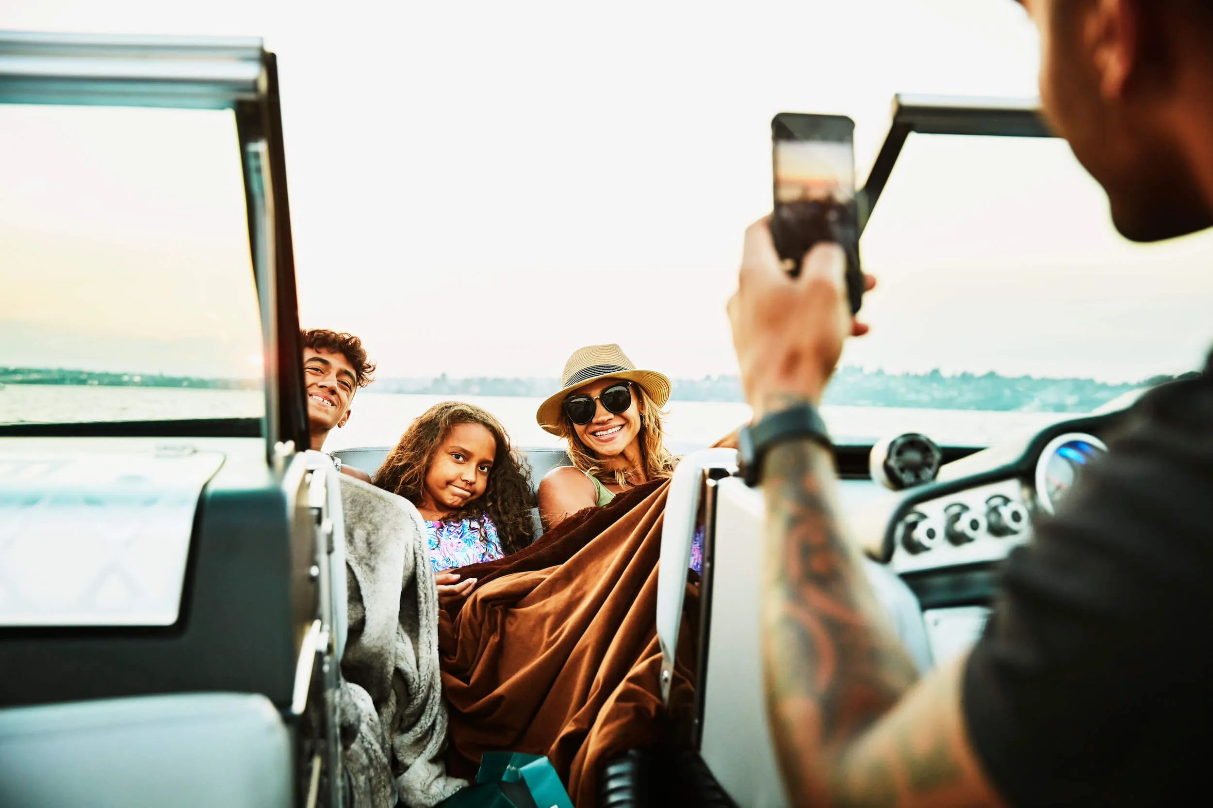 Man takes a photo of his family on a boat