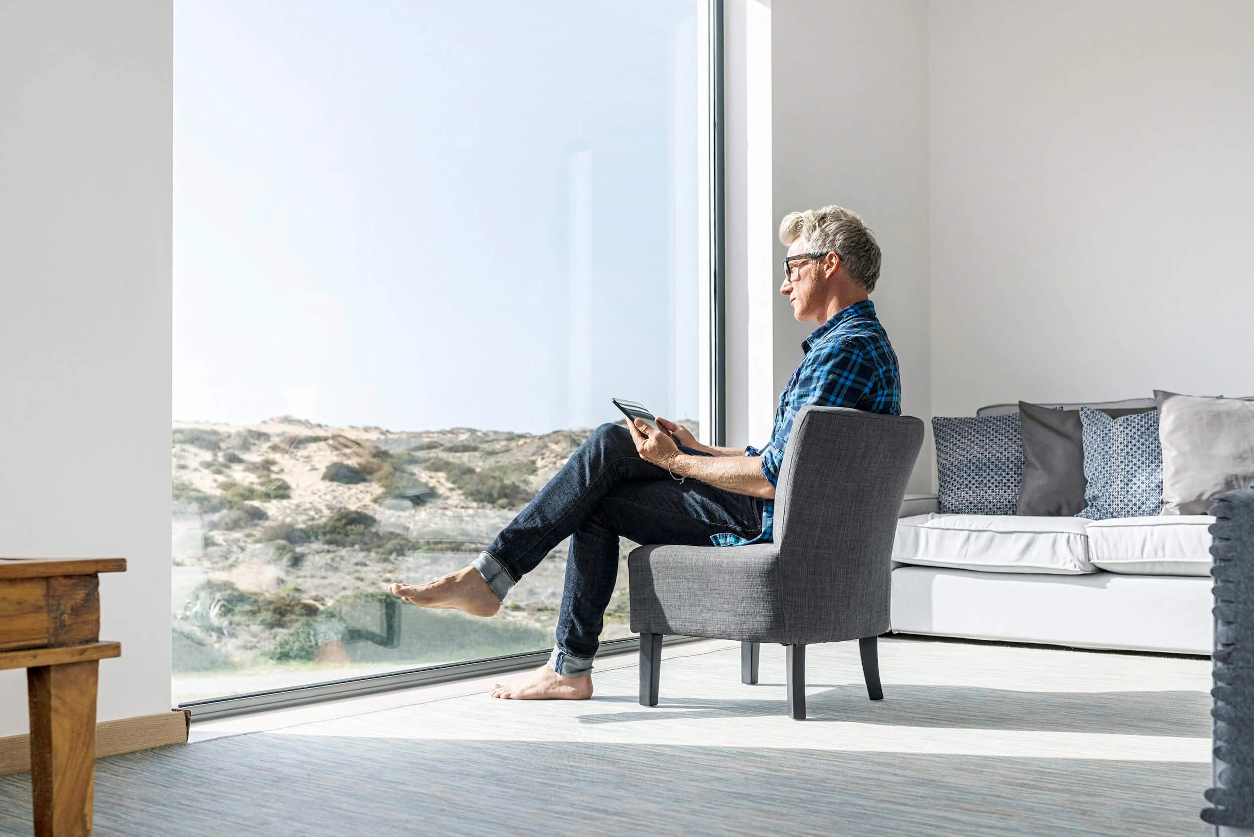 A man views scenery through a window while sitting in a seat