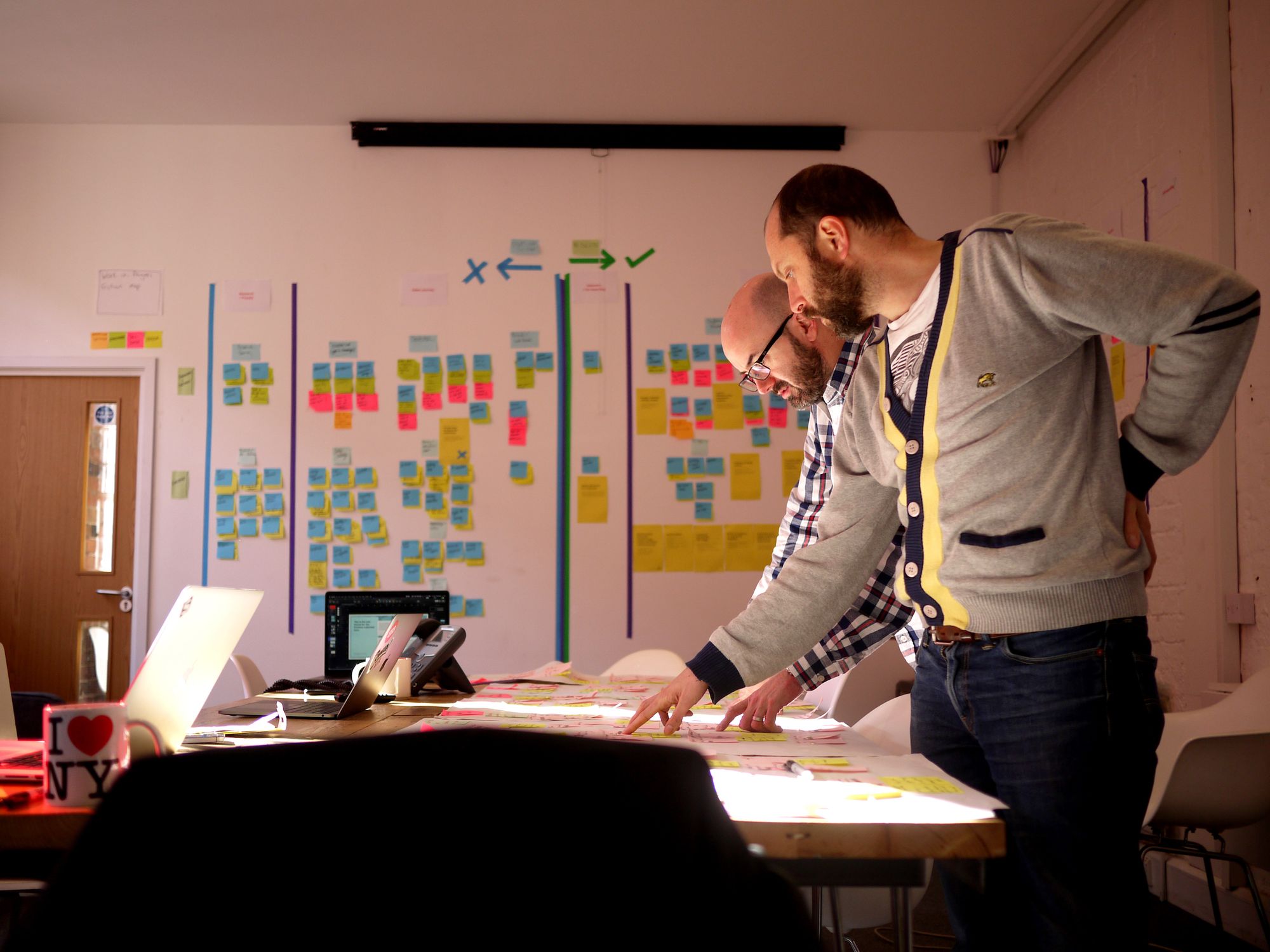 383 team members working on VWFS Friction Mapping® project. Post-it notes on the wall behind them and sharing thoughts on a Friction Map on the desk.