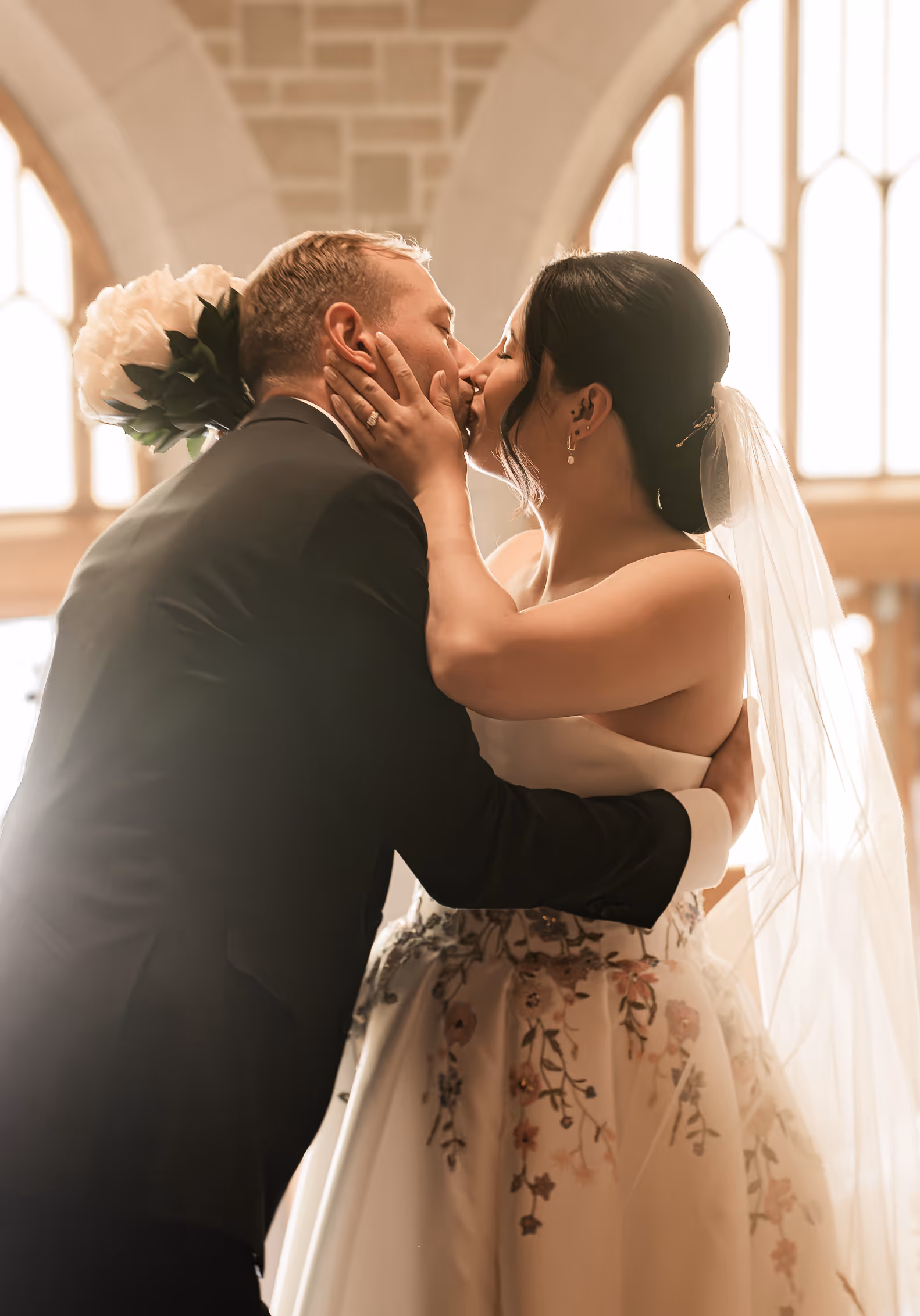 A man and a woman sharing their first kiss as a married couple.