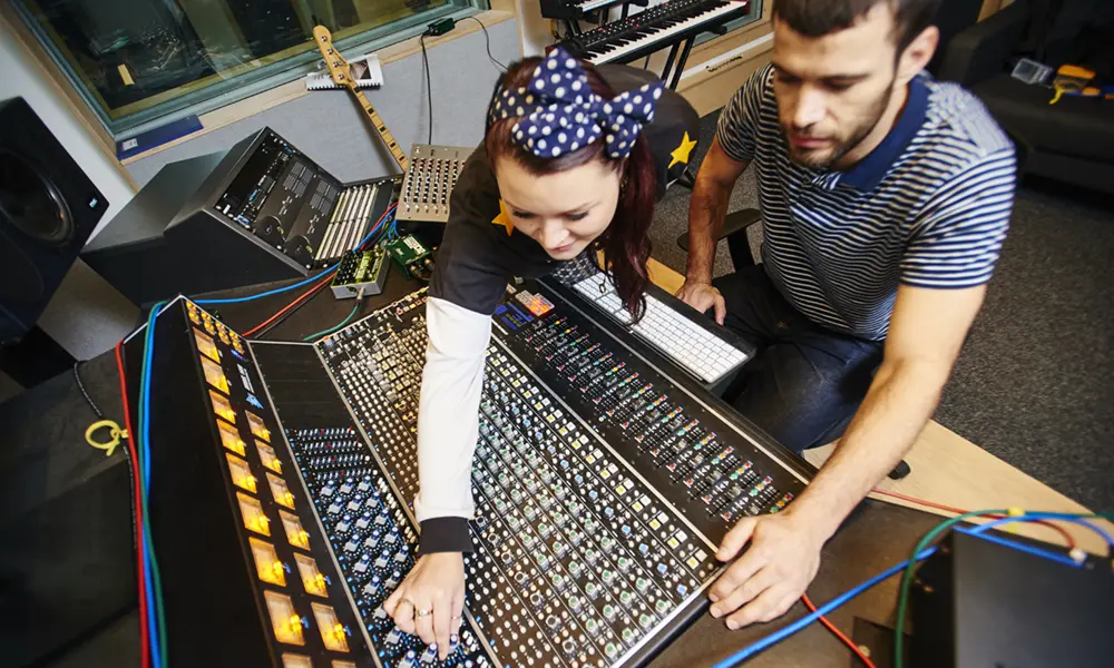 A man and woman using a mixing desk