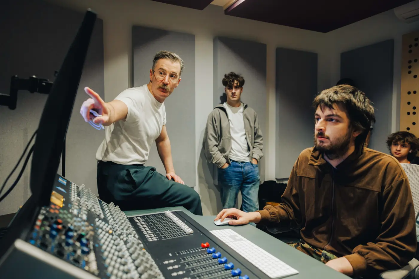 A dBs tutor mentoring students in a production studio