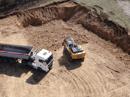 Bagger und LKW bei Baugrube