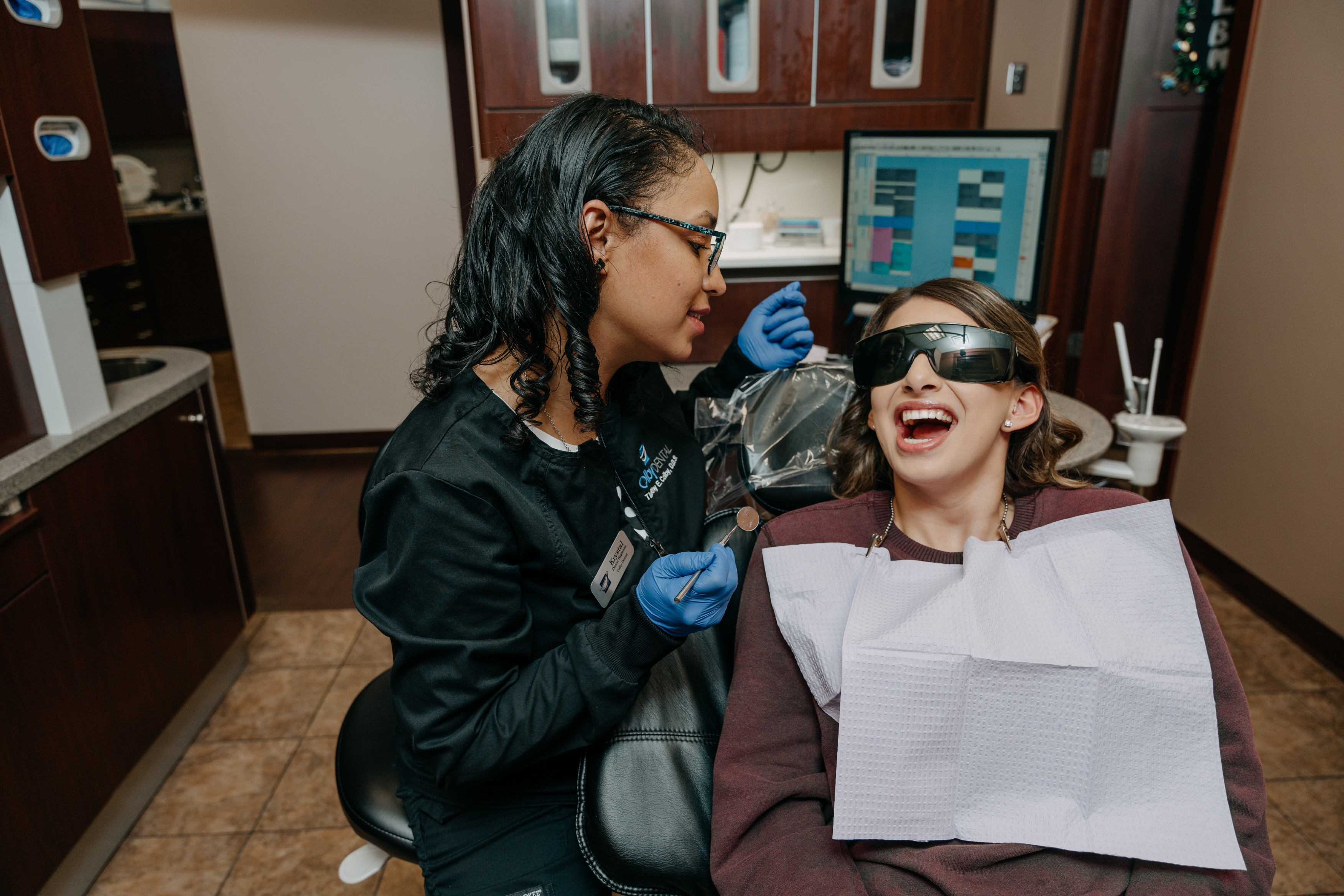 Dr. Marcus Biggs, D.D.S, one of the dentists at Colby Dental in Highland, speaks to a female dental patient who is sitting in a dental chair