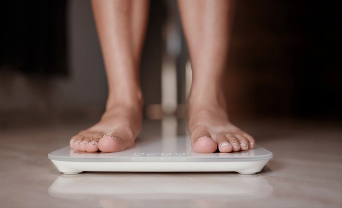 Person on scale checking their weight to see if they qualify for bariatric surgery.