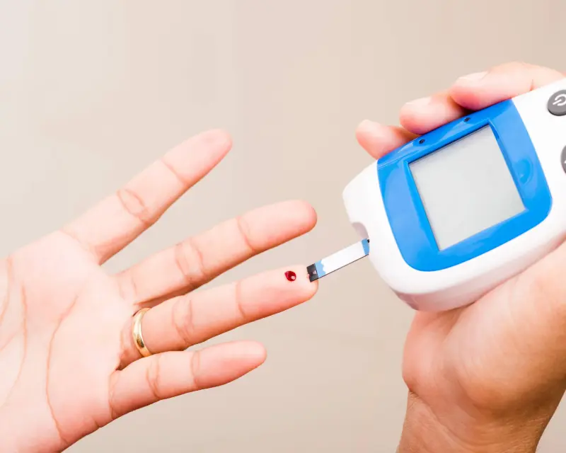 Diabetic patient checking their blood sugar level to see if it went down after bariatric surgery.