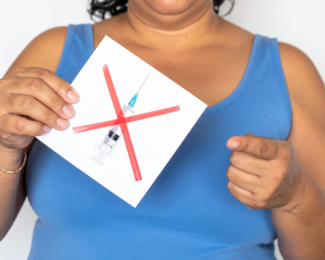 Patient holding an image of a weight loss injection syringe crossed out, representing concerns about medication coverage in California.