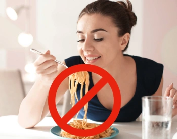 Woman about to eat pasta with a “not recommended” symbol, representing foods to avoid after gastric bypass surgery
