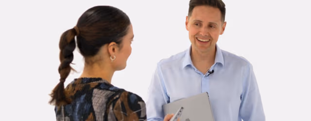 Professional man and woman discussing workplace coaching.