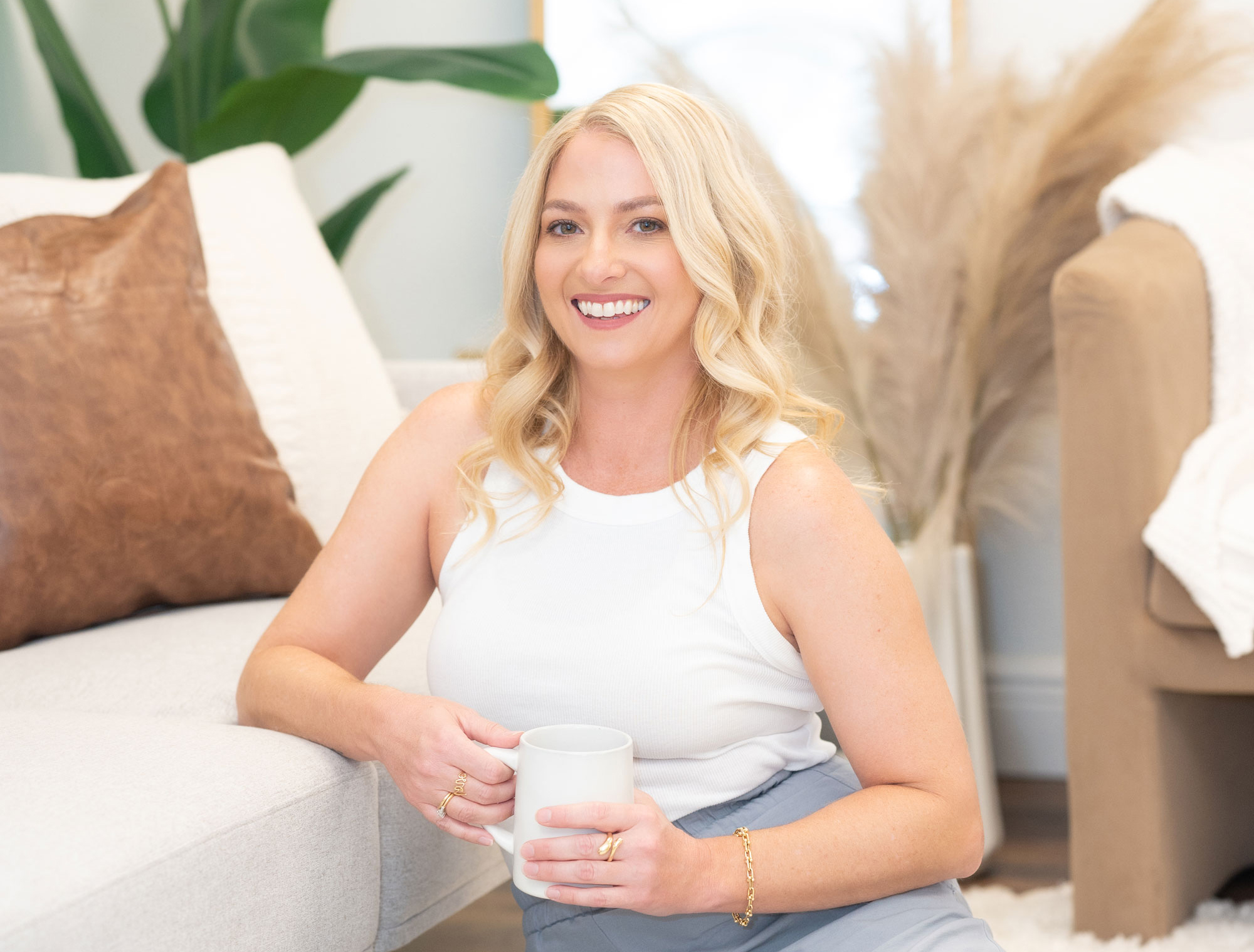 Anne-Marie Wurzel, top Central Florida Realtor, smiling with a coffee mug in a stylish Oviedo home interior