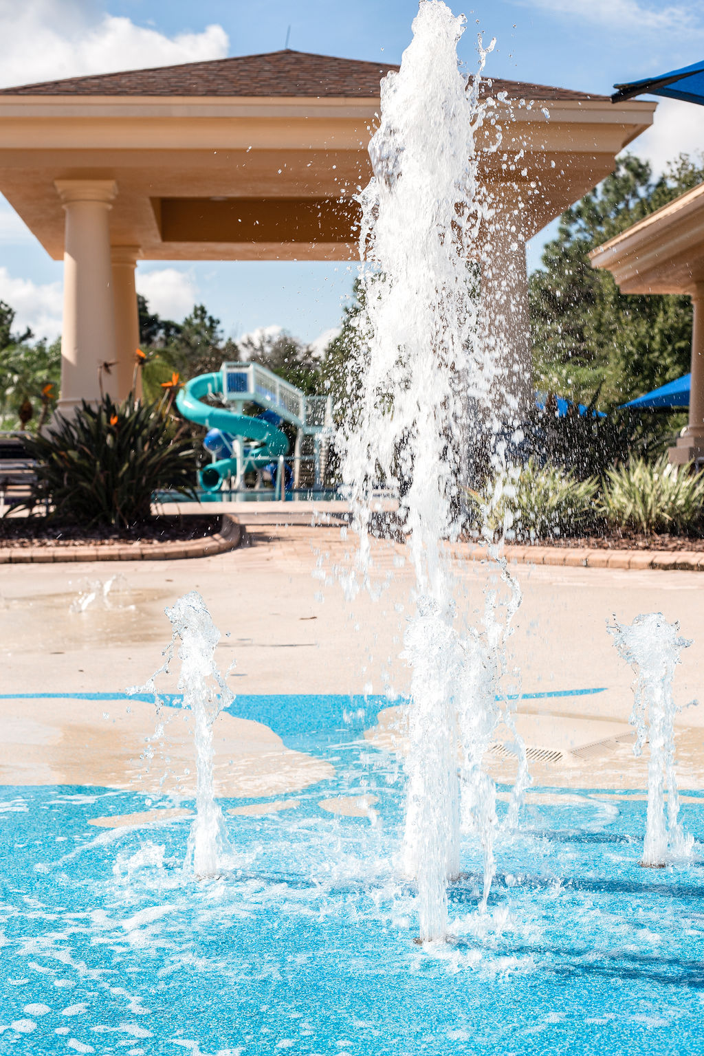 Splash pad with water jets and a waterslide in Live Oak Reserve community area