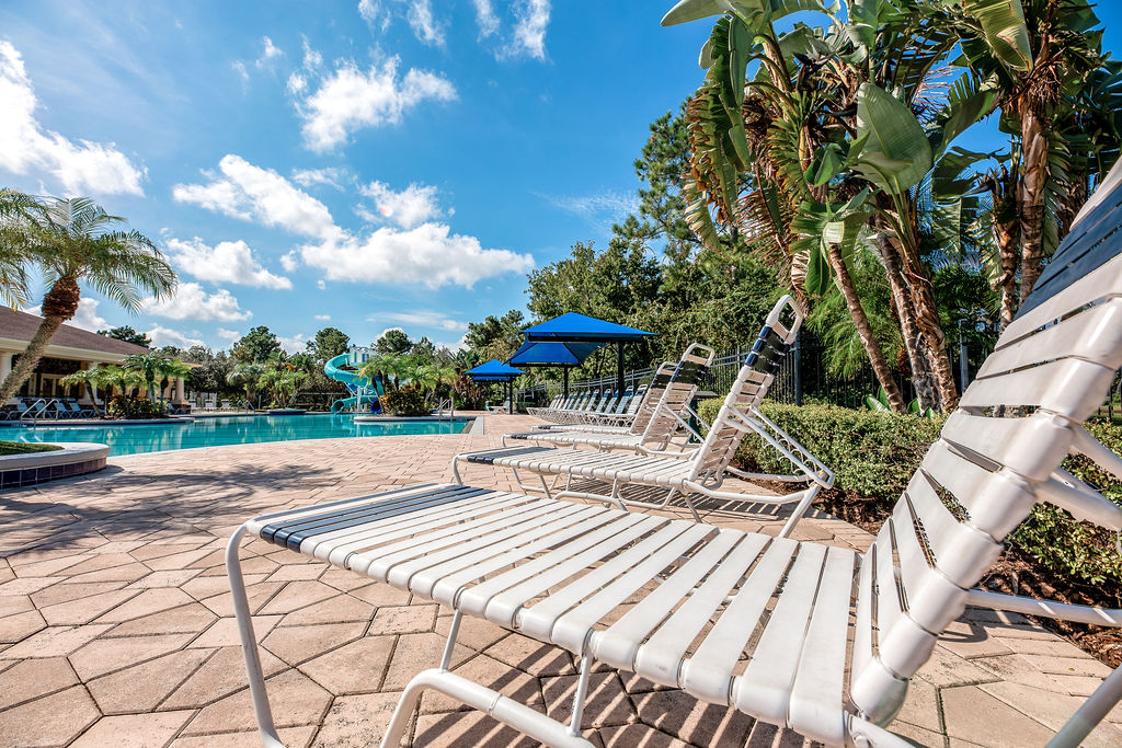 Lounge chairs around resort-style pool under blue skies in Live Oak Reserve, Oviedo FL