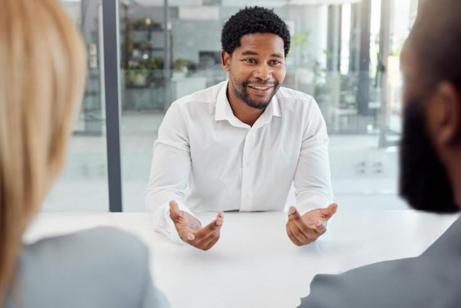Black businessman meeting or job interview in office boardroom with human resources recruitment or corporate hiring managers Talking worker employee or hr candidate with happy smile or motivation