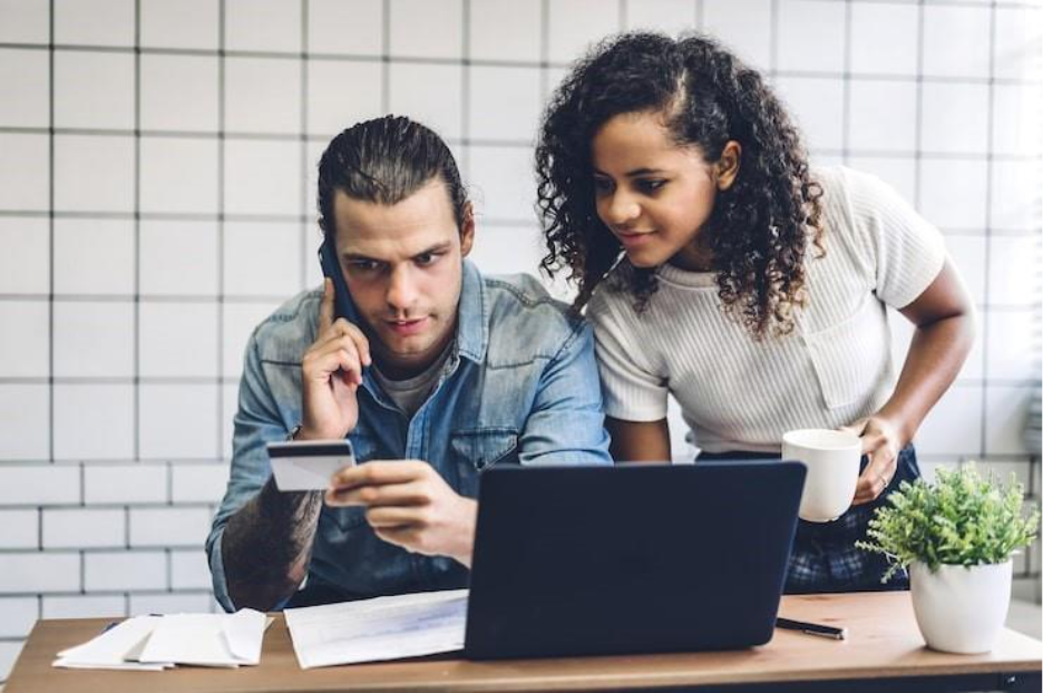 Man holding credit card wile talking over phone by woman with coffee cup at table kyc software. KYT compliance and know your transaction