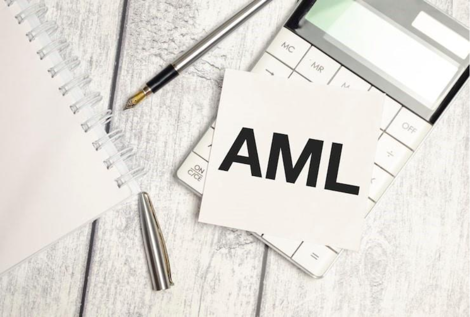 On the wooden desk is a sheet of paper with the inscription AML AntiMoney Laundering