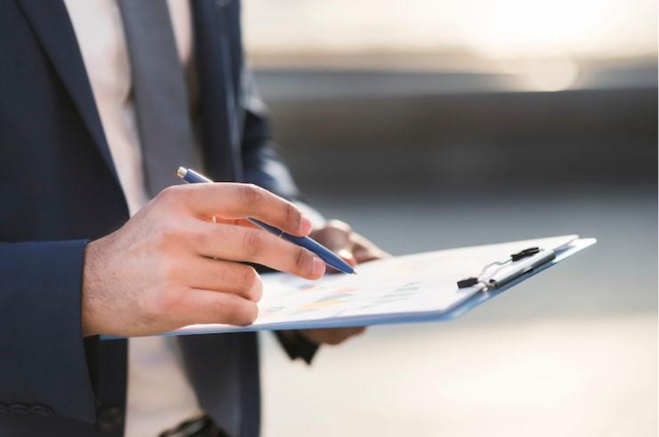 Close-up business man checking clipboard to represent the checklist for background checks. 