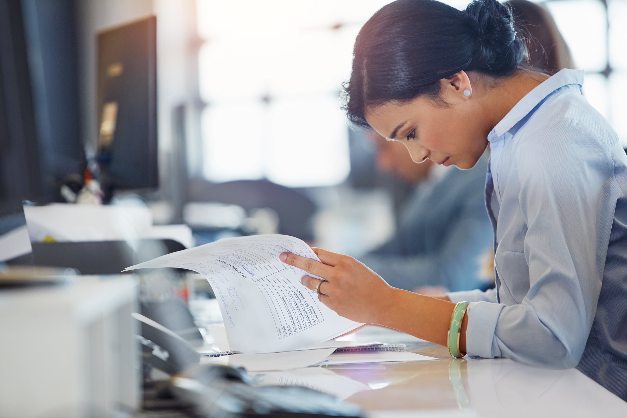 A professional reviewing deal documents at a desk
