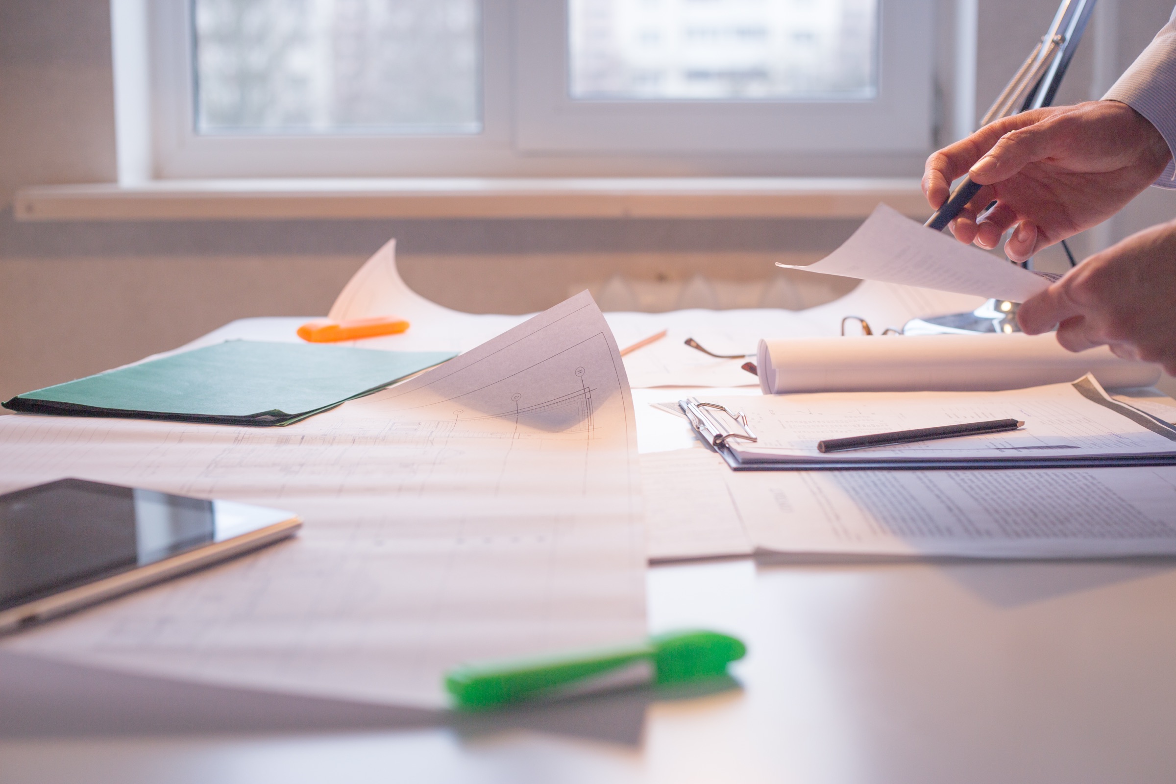 Source documents and files spread across a desk during a records review