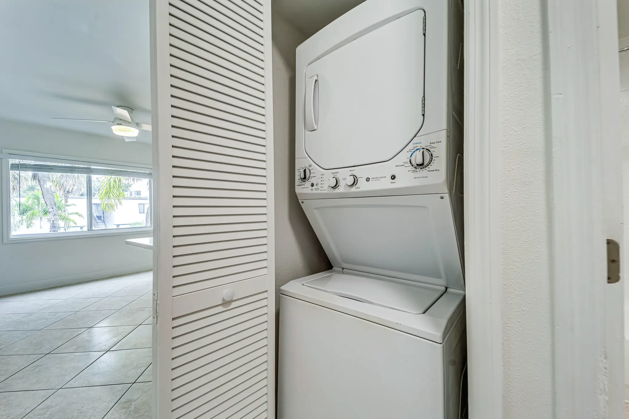 In-Unit laundry facing toward window overlooking swimming pool.