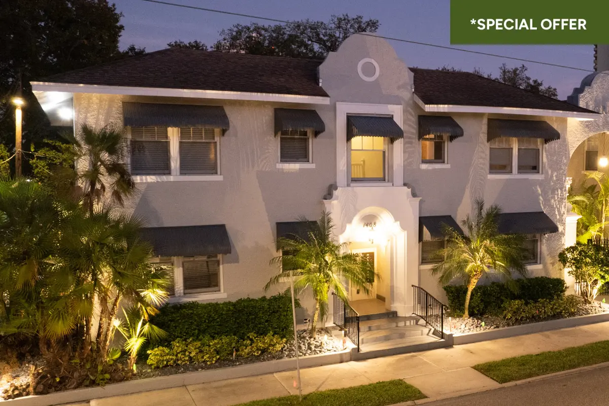 View of front facade of apartment building with with gated fountain courtyard with archy way stating "Lorenzo" with text overlay stating "*special offer."