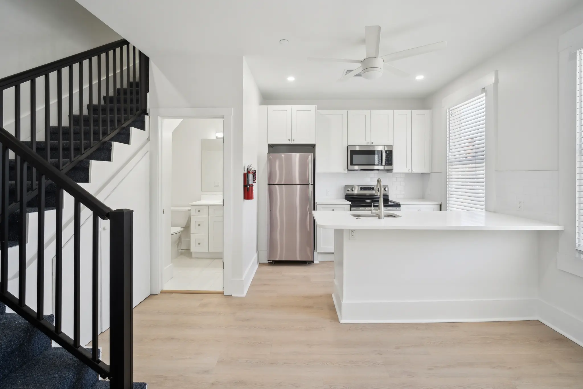 Spacious and bright living room facing gorgeous modern kitchen with stainless steel appliances.