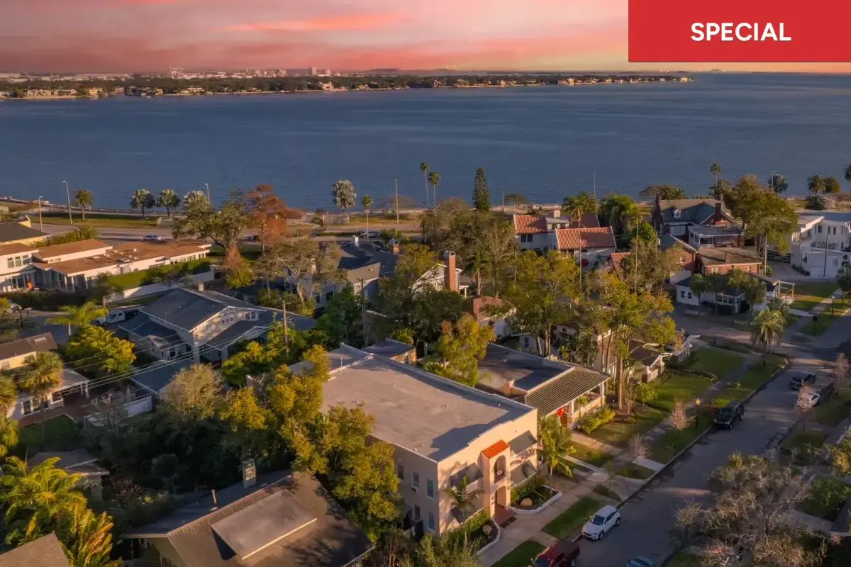 Aerial view of a picturesque neighborhood by the water, lit by a sunset sky with text overlay stating "special."