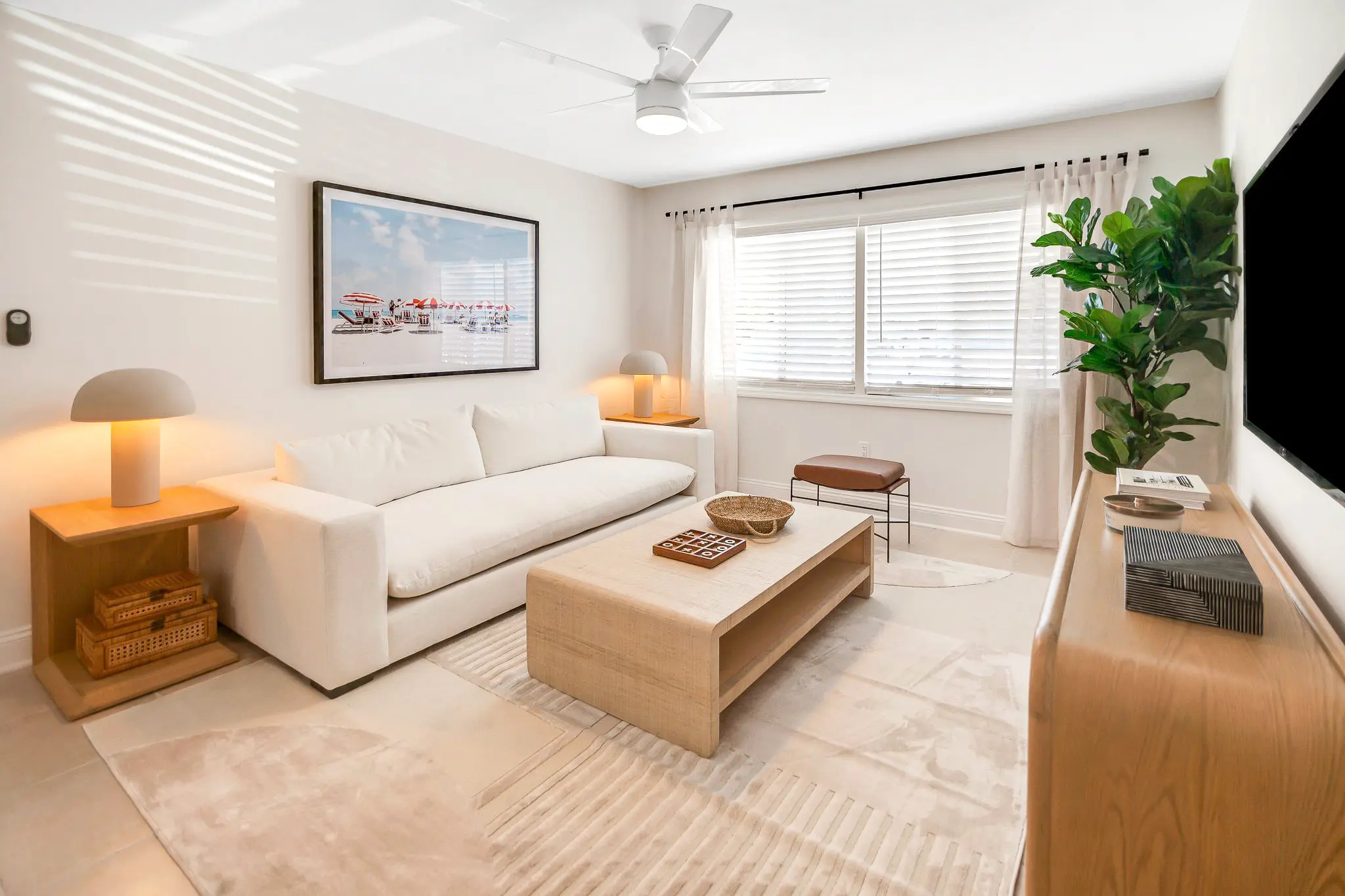 Contemporary living room with a large window, potted plant, and minimalist decor.