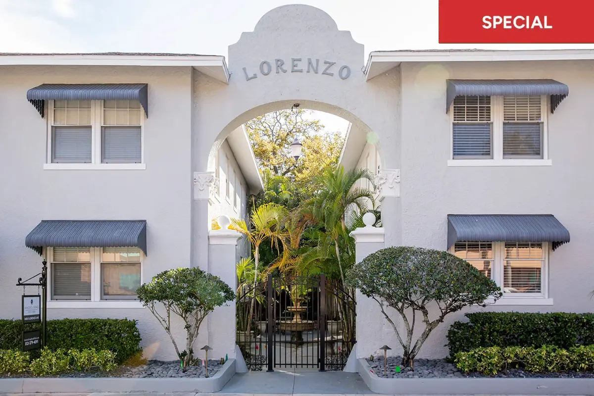 View of front facade of apartment building with with gated fountain courtyard with archy way stating "Lorenzo" and text overlay stating "special."