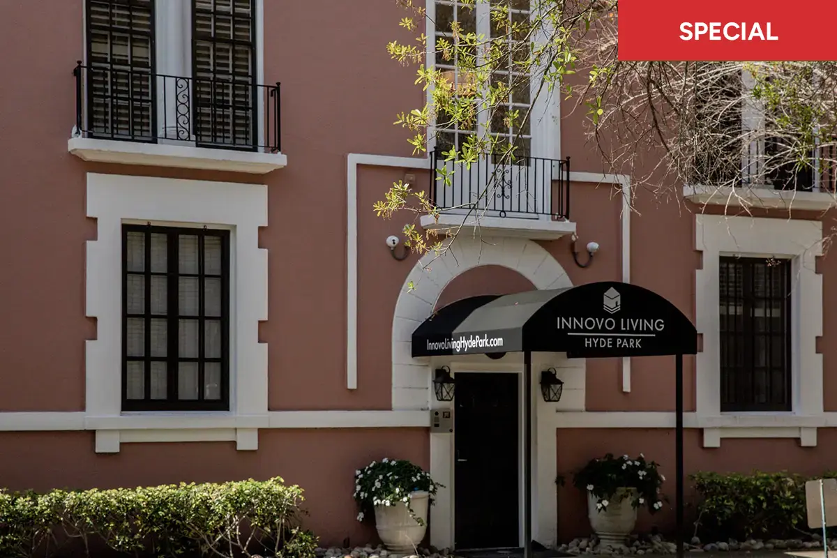 Pink Clewis exterior with black awning and lush green bushes with red banner and text overlay stating "special."